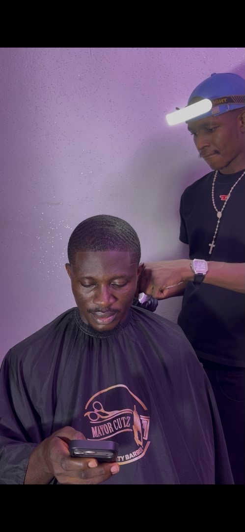Mayor Cutz barber working on a client mid-cut